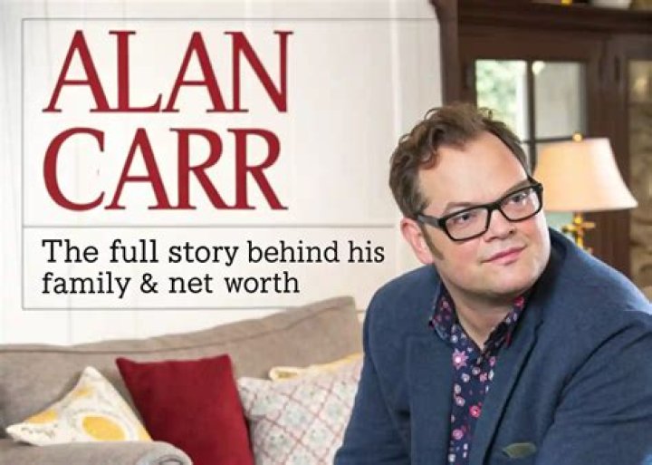 Alan writes a note in The Patient Episode 6. Alan sits in a chair wearing a white button-down and green cardigan. 